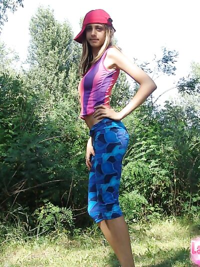 Έφηβη σόλο κάνει γυμνό ντεμπούτο δίπλα σε πεύκα με καπέλο τραβηχτό στο πλάι.